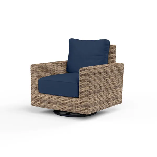 Outdoor swivel club rocker chair with weathered tobacco wicker and navy blue cushions on a round black base