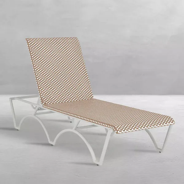 Side angled view of chaise showing curved white aluminum legs and woven wicker surface