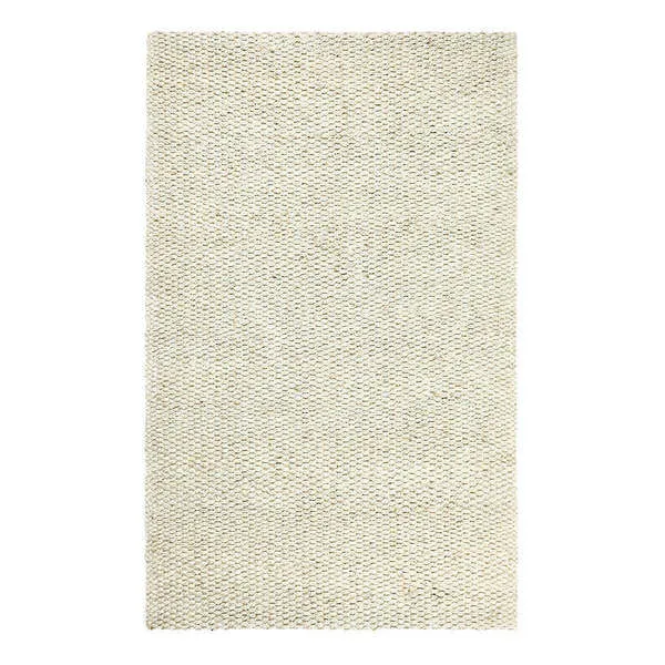 Handwoven jute area rug in neutral ivory tones with thick braided texture and natural fiber weave