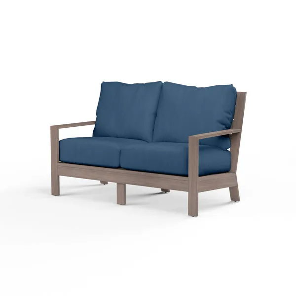 Laguna Loveseat outdoor sofa with driftwood-finish aluminum frame and deep blue cushions