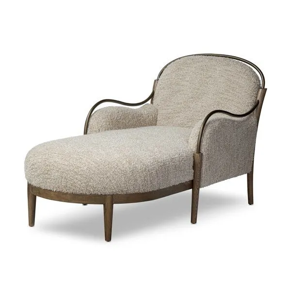 Demi Chaise shown in a three-quarter angle highlighting curved burnished brass arms and textured upholstery