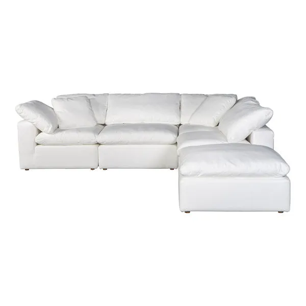 White modular sectional sofa with plush cushions and a right-side ottoman in a minimalist Scandi style