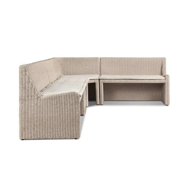 L-shaped outdoor dining banquette in vintage white rattan with soft fabric seat cushions
