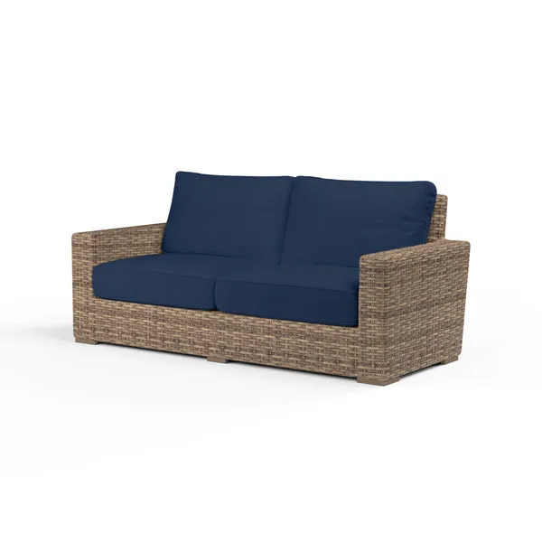 Havana Loveseat with rich Aged Tobacco all-weather wicker frame and deep navy blue cushions, designed for outdoor comfort