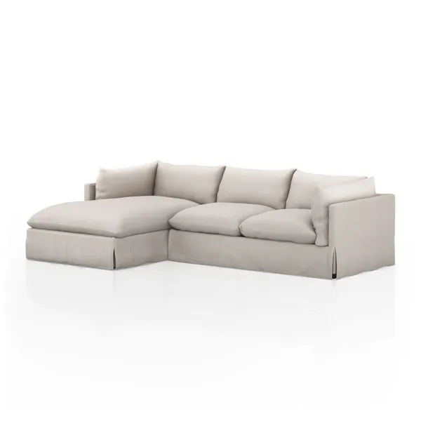 Neutral slipcovered 2-piece sectional with left-facing chaise, pillow cushions, and shelter-style arms