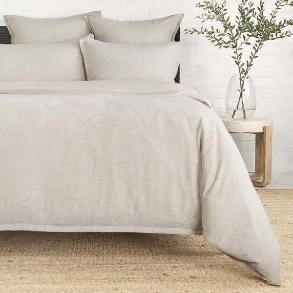 Natural beige Georgie duvet on bed with subtle texture, paired with matching pillow shams in minimal bedroom setting