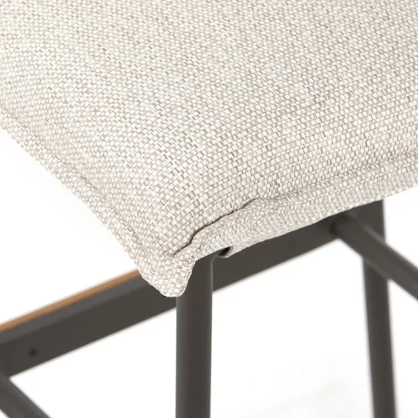 Vega Faye Ash Outdoor Counter Stool with ash-colored upholstery, dark bronze iron base, and teak stretchers