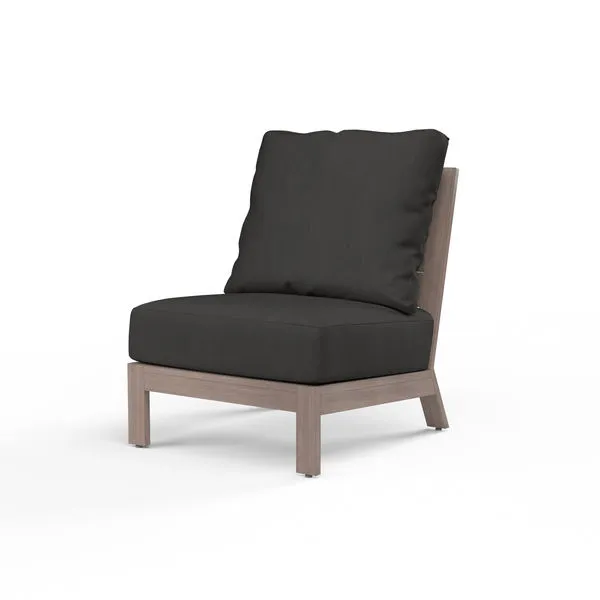 Laguna Armless Club chair with driftwood-finish aluminum frame and dark gray cushions, curved slat back and plank arms