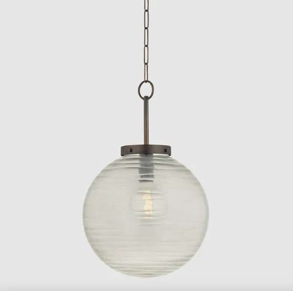 Falls Mills pendant with round Murano-inspired glass globe featuring subtle swirl texture and aged brass hardware