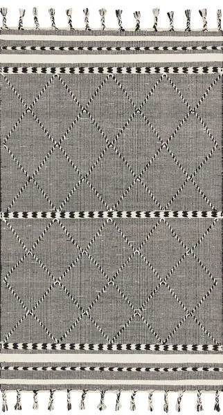 Sawyer Black Rug with bold black and white geometric diamond pattern and fringe on ends