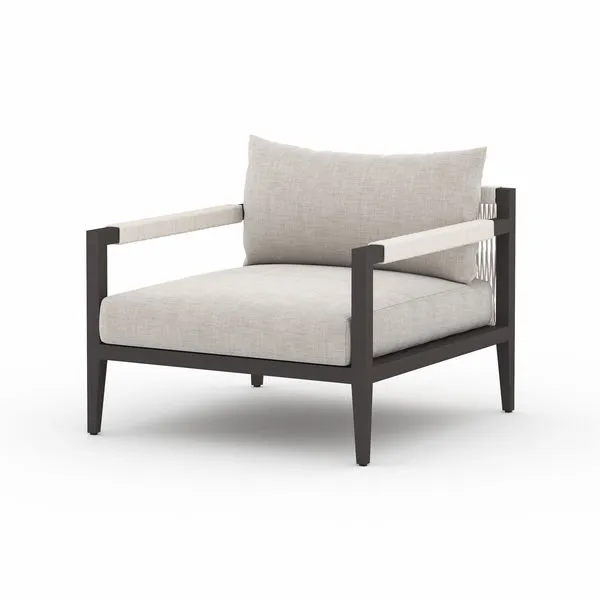 Sherwood Stone Grey outdoor chair with bronze-finished aluminum frame, Sunproof stone grey cushions, and rope-wrapped armr...