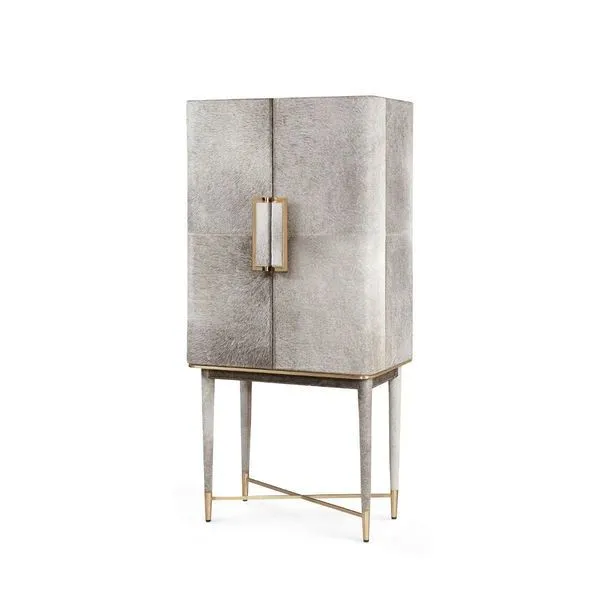 Tall bar cabinet draped in plush gray hair-on-hide with polished brass accents on legs and handles