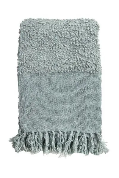 Murphy oversized throw in soft blue with bouclé texture, texture blocking pattern, and tassels at edges