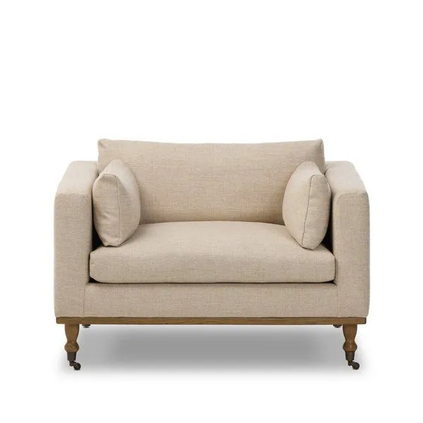 Harlin Chair with elongated bench seat, boxy arms, wheat neutral performance fabric, turned oak legs with brass casters