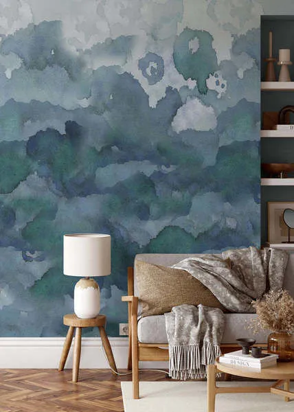 Wall mural wallpaper with abstract watercolor pattern in shades of blue and green, shown in a living room setting