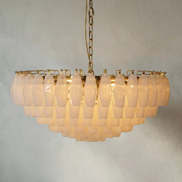 Tiered Murano-style chandelier with faceted opaline glass prisms on polished brass frame, glowing softly