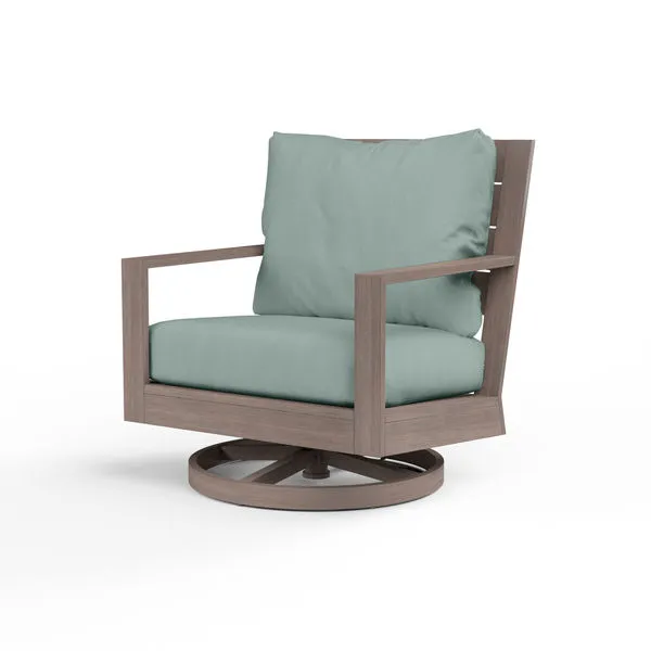 Laguna Swivel Club Rocker outdoor chair with hand-brushed driftwood aluminum frame and light blue cushioned seat and back