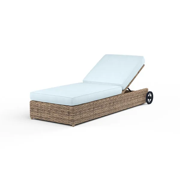 Outdoor adjustable chaise lounge with aged tobacco all-weather wicker base and light blue cushions