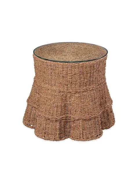 Round end table with hand-woven seagrass draped over metal frame and glass tabletop, natural tan color