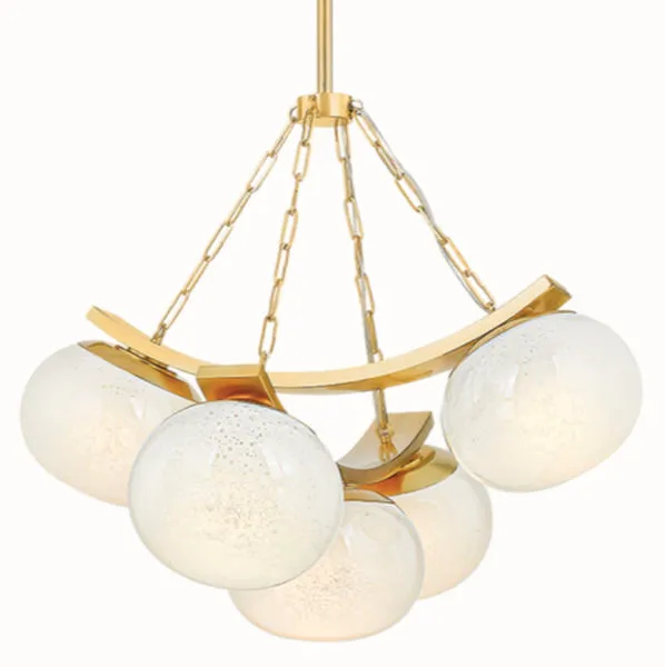 Duxbury Chandelier showing light glowing through seedy glass shades with brass metal detail and chains