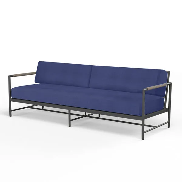 Outdoor Pietra Sofa with matte graphite aluminum frame and deep blue cushions, mid-rise back and slim armrests