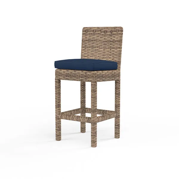 Havana Counter Stool in aged tobacco wicker with navy blue cushion, tall wicker legs, and supportive backrest