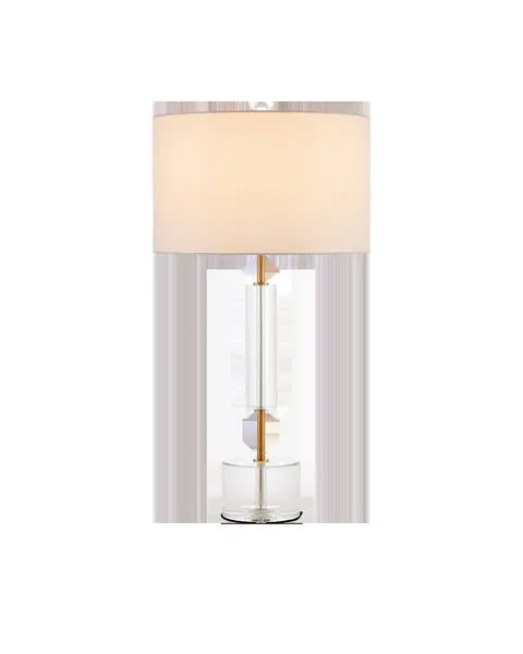 Deville Table Lamp with antique brass thin metal stem, clear optic crystal base and cylinder, topped with white drum shade