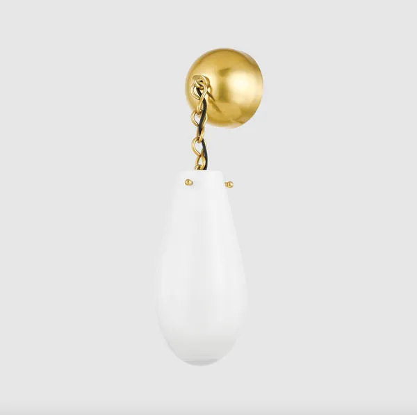 Clarkstown Wall Sconce mounted on light gray wall with warm brass canopy and white glass shade