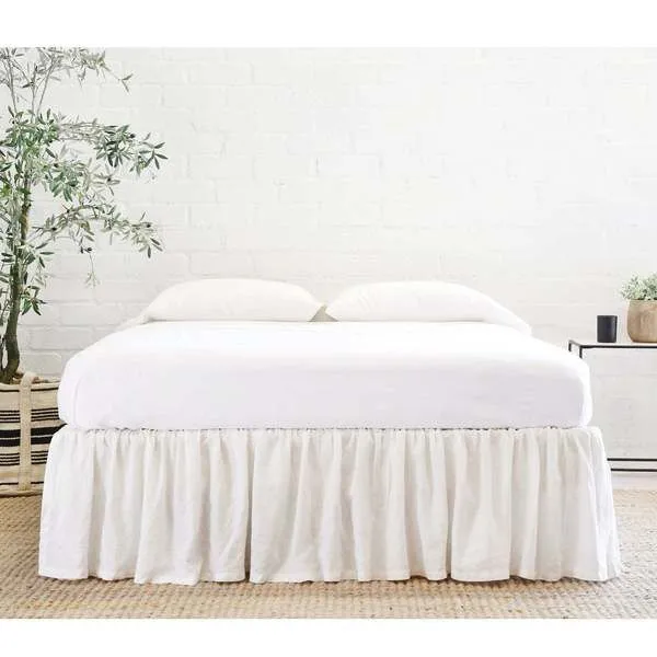 Gathered cream linen twin bed skirt with soft gathers around full bed base in light neutral bedroom setting