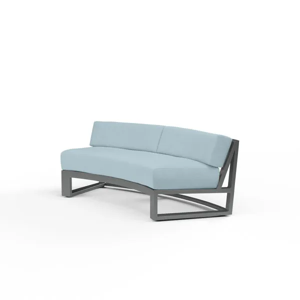 Curved outdoor sofa with low back, powder coated aluminum frame in brushed slate, and light blue cushions